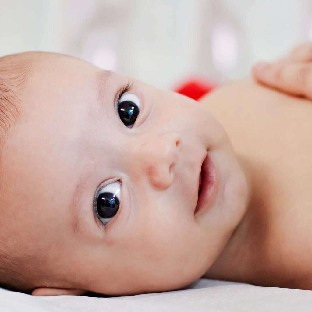 Bebê sorridente representando a saúde da criança com acompanhamento médico em Cataguases