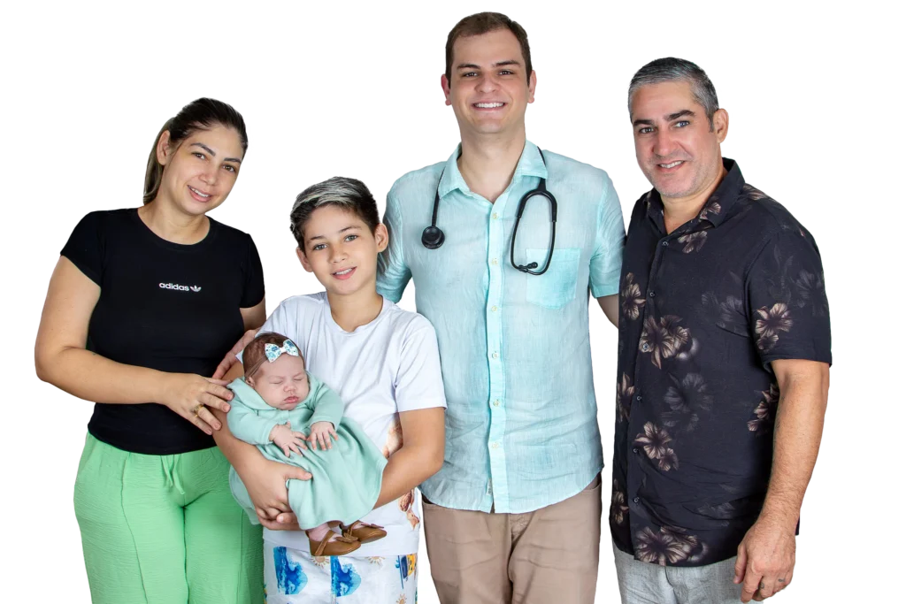 Médico de Família e Comunidade Dr. Breno Sahb sorridente ao lado de uma família.